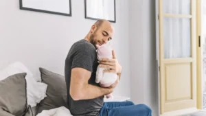 Pai amoroso segurando bebê recém-nascido em quarto aconchegante durante período de licença-paternidade